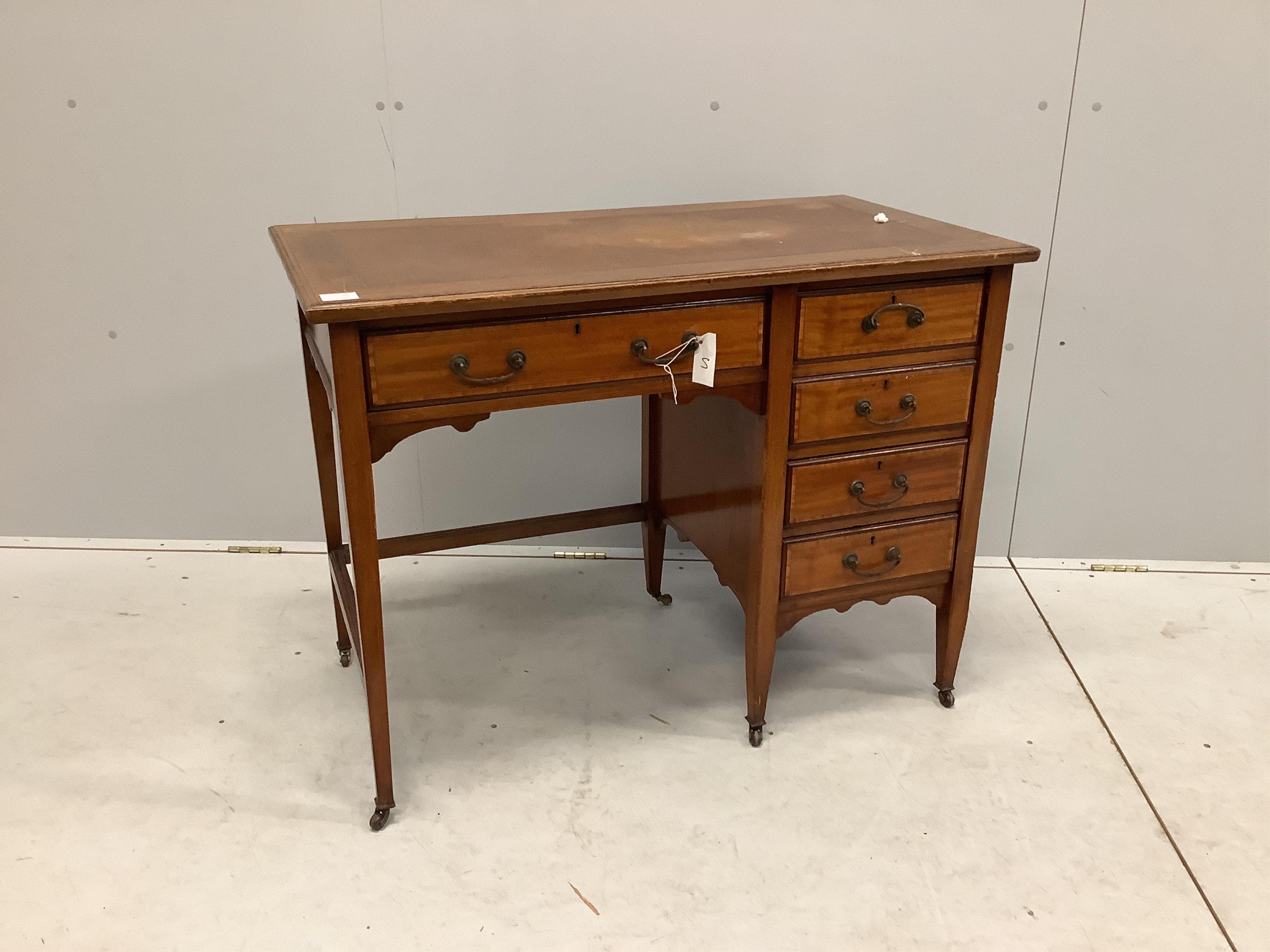 An Edwardian crossbanded mahogany kneehole desk, with moulded edge fitted one frieze drawer and four pedestal drawers, all with brass loop handles, set on square tapered legs with castors, width 99cm, depth 53cm, height